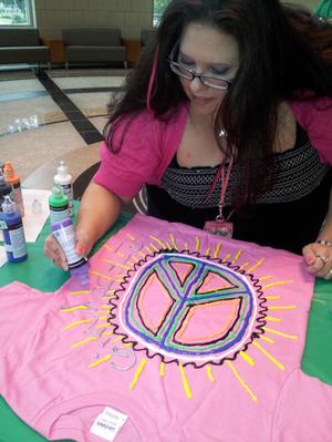 [Woman making peace sign shirt from Clothesline Project]