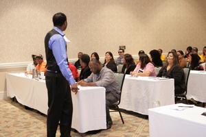 [Man speaking to table groups at 2012 TABPHE workshop 1]