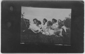 [Seven women lounging in the grass]