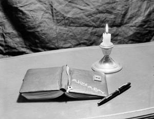Primary view of object titled '[Photograph of a diary and a candle]'.