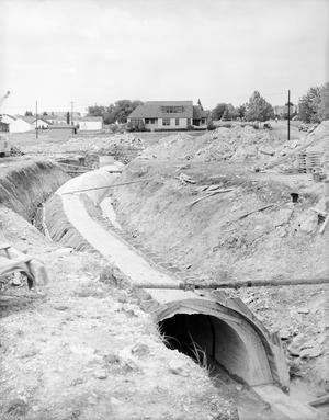 [Photograph of a large pipe in a construction site]