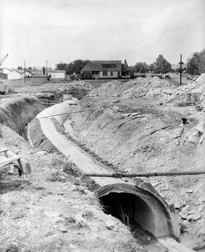 [Photograph of a pipe running through a construction site]