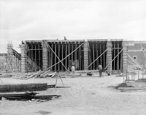 [Photograph of workers building a stadium]
