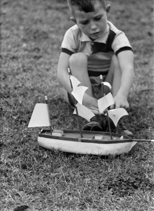 [Photograph of Tim Williams playing with a toy boat, 7]