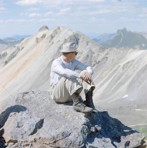 [A man sitting on a mountain]