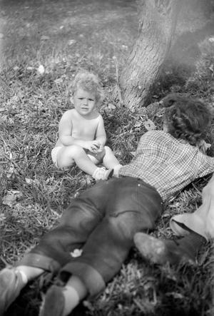 [A child sitting in the grass]