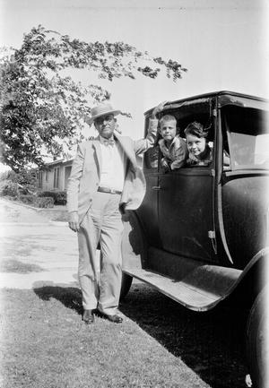 [A man and two children with an automobile]