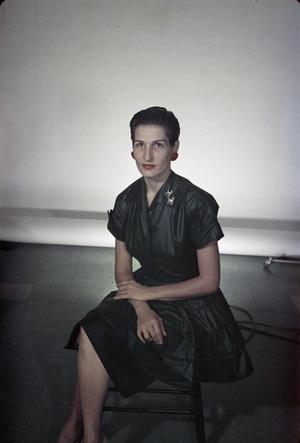 [Doris sitting, wearing a green dress and red earrings]