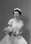 Photograph: [Frieda Warrington in a lace dress, holding a bouquet]