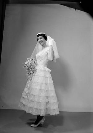 [Kathleen Zimmerman standing, wearing a layered dress and veil and holding a bouquet, 2]