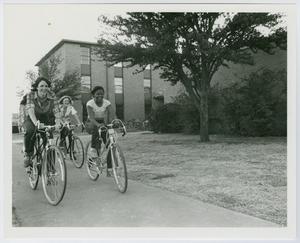 Primary view of object titled '[Female students on bicycles in front of West Hall]'.