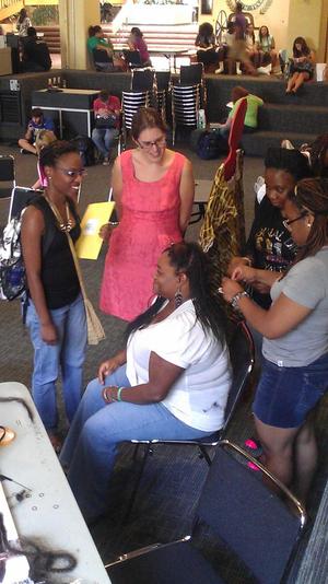 [Woman having her hair braided at MC event]