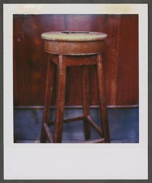 [Wooden stool in front of a wooden wall]