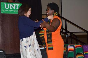 [Faculty giving student Kente stole]