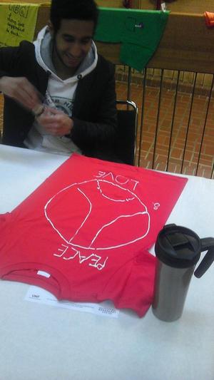[Student decorating red Clothesline Project t-shirt]