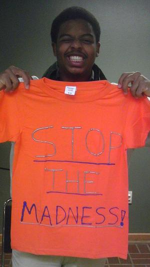 [Student holding an orange Clothesline Project t-shirt]