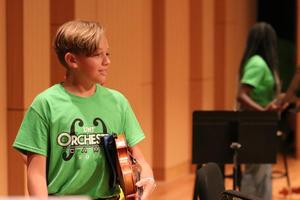 [Student holding a violin at the UNT Music Summer Orchestra Day Camp]