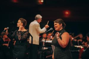 [Two singers performing on stage with the Symphony Orchestra at the UNT College of Music Gala]