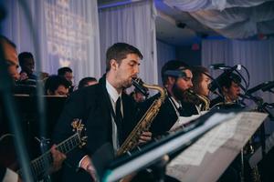 [Musician playing the saxophone and other musicians performing at the reception for the UNT College of Music Gala]