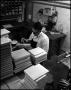 Photograph: [Book Bindery - Process - Male Individual - Glue - 1963]