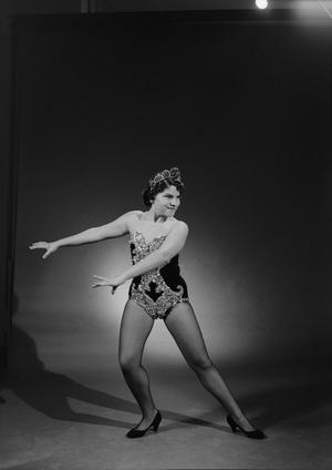 [Brenda Leibowitz in an embellished leotard, both arms out to the side]