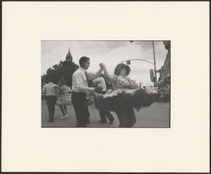 Primary view of object titled '[A man twirling a woman in the streets of Denton]'.
