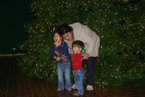[Woman and children pose in front of Christmas tree at UNT Tree Lighting Ceremony]