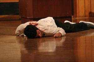 [Photograph of a man playing dead at murder mystery dinner]