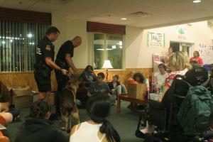 [Photograph of UNT students watching Ben the police dog at Traditions Hall]
