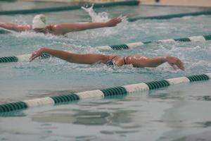 [Photograph of Swimming and Diving members doing butterfly stroke]