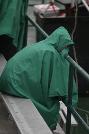 [Photograph of a person in the stands at Fouts Field wearing a rain poncho]