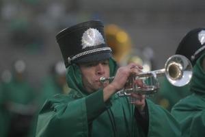 [Photograph of a Green Brigade trumpet player performing at football game]