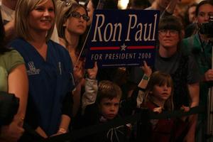 [Photograph of a young boy holding a Ron Paul sign]
