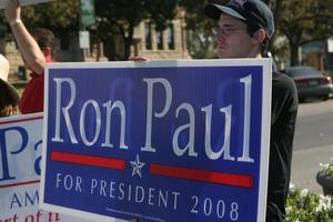 [Photograph of a man holding a Ron Paul sign on the Square]