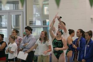 [Women's Swimming and Diving members and coaches cheer on from the sidelines]