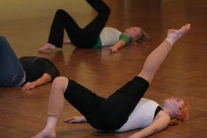 [Photograph of a woman stretching at UPC dance class]