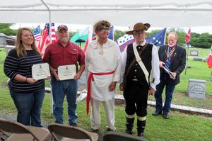 [Dorchester family members hold certificates at grave marking ceremony for C.B. Dorchester]