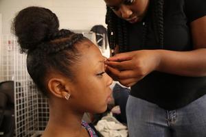 [Student applies false eyelashes at 2016 TBAAL Summer Youth Arts Institute]