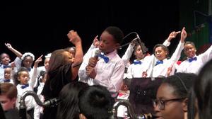 [Boy sings with Charles Rice choir at 23rd annual Christmas Kwanzaa concert]