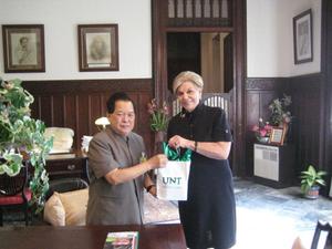 [Man 3 receives gift from Gretchen Bataille at Thailand delegation meeting]