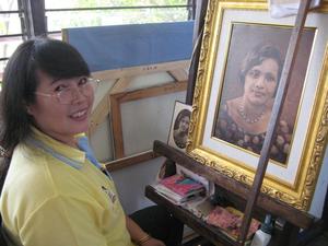 [Woman with painted portrait in Thailand classroom]