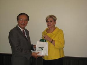 [Man 1 receives gift from Gretchen Bataille at NIDA delegation meeting]