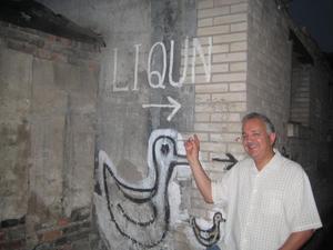 [UNT faculty member poses with "liqun" graffiti]