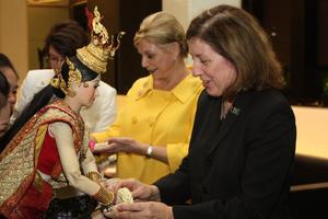 [Woman receives garland from Thai puppet]