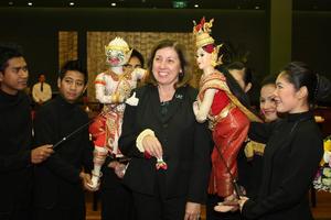 [Woman poses with Thai puppets, 2]
