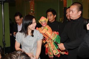 [Female audience member poses with Thai puppet]