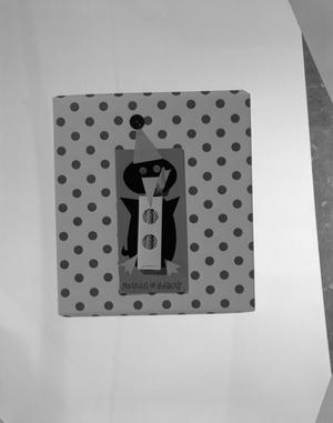 [Product photograph of a Christmas gift wrapped in patterned paper and a paper arts penguin]