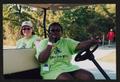 Primary view of [Volunteer duo riding in a golf cart: Lone Star Ride 2002 event photo]