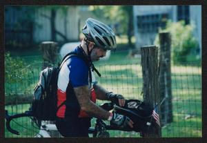 [Route planning chair Richard Treat unzipping a bag: Lone Star Ride 2002 event photo]