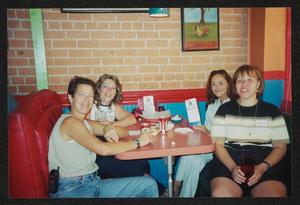[Four women seated at a red booth table: Lone Star Ride 2003 event photo]
